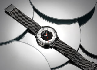 Doppio Mirror Limited Edition, Edelstahl, 41 mm, Uhr mit Milanaise-Armband auf verspiegelten Glasscheibe